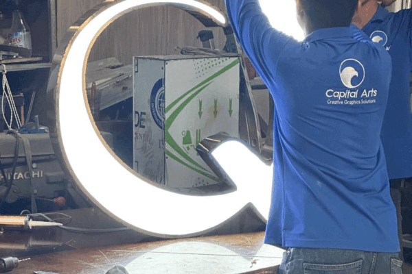 Capital Arts Fabrication Team – 3D Illuminated Signage Production Capital Arts production team assembling large front-lit 3D illuminated letters in the signage manufacturing workshop.