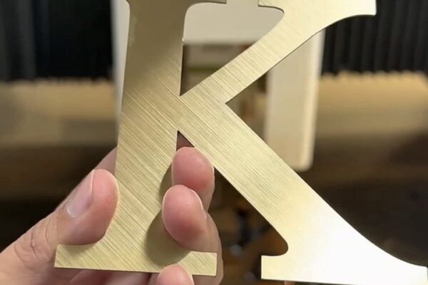 Capital Arts CNC Router – Precision Acrylic Letter Cutting CNC routing machine precisely cutting out 3D solid acrylic letters from a large sheet in the Capital Arts manufacturing workshop.